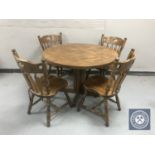 A circular oak pedestal kitchen table together with four chairs