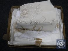 A box containing an early 20th century Christening gown together with a hand-embroidered table