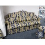 A three-piece lounge suite upholstered in Regency style striped fabric