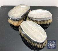 Three silver backed brushes