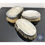Three silver backed brushes