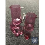 Two early 20th century cranberry glass jugs together with six small beakers