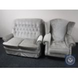 A two seater buttoned back settee upholstered in fabric together with similar wingback chair