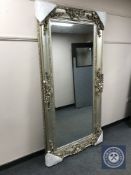An ornate silvered floor standing mirror,