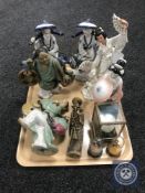 A tray containing six oriental style porcelain figures together with a carved resin figure,