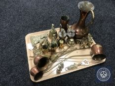 A tray containing assorted brass and copper ware including copper drinks measures,