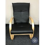 A pine framed black leather armchair