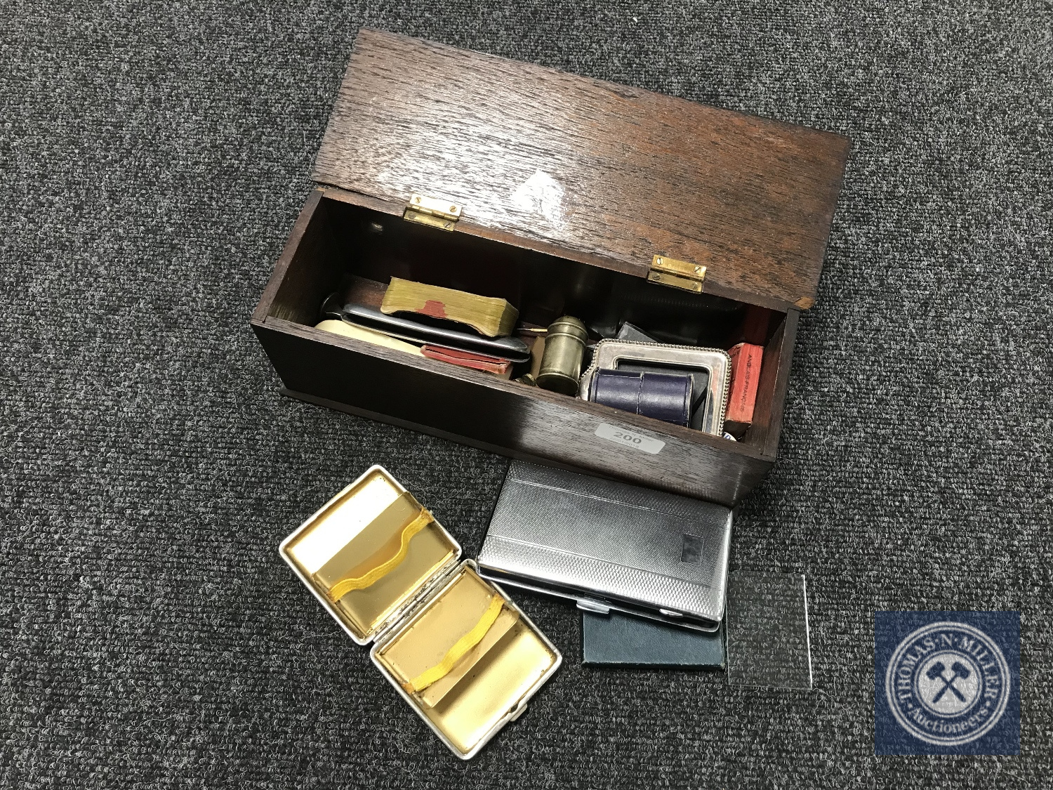An oak box containing silver plated items including small photo frame, cigarette box etc,