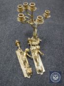 A decorative brass six-way table candelabrum together with a pair of brass cherub sconces