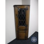 A reproduction oak leaded glass door corner cabinet