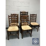 A set of five rush seated ladder backed kitchen chairs (one carver and four singles)