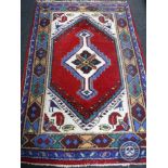 A woollen Persian design rug,