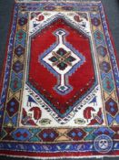 A woollen Persian design rug,