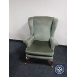 A twentieth century wingback armchair upholstered in green dralon