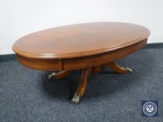 An oval inlaid mahogany pedestal coffee table