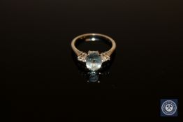 An 18ct white gold aquamarine and diamond ring, an oval-cut aquamarine within a claw setting,