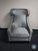A contemporary high back armchair in a silver fabric