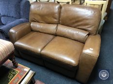 A brown leather manual reclining two seater settee