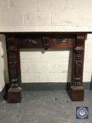 A carved reproduction mahogany fire surround