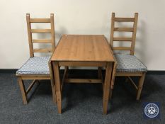 A pine drop leaf kitchen table and two chairs
