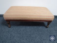 An oversized footstool in striped fabric