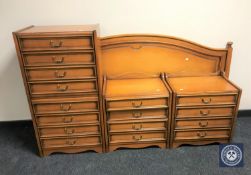 A five-piece bedroom set in teak finish (five drawer dressing chest, eight drawer chest,