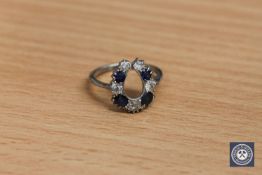 An antique platinum horseshoe ring, set with sapphires and old cut diamonds,