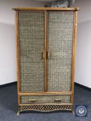 A wicker double door wardrobe fitted a drawer