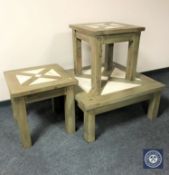 A pine coffee table and pair of matching lamp tables with inset travertine tiles