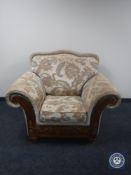 A wooden framed armchair upholstered in Regency style fabric