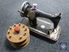 A vintage Singer hand sewing machine together with a bobbin stand
