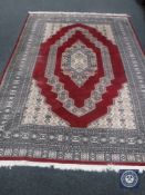 An Eastern design carpet on red ground,