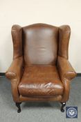 A Laura Ashley brown leather wing backed armchair, width 83 cm.