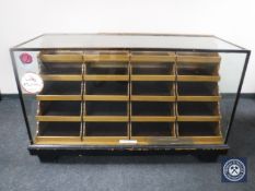 An early 20th century glazed haberdasher's display cabinet fitted twenty pull out trays