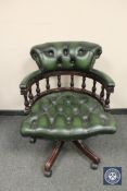 A buttoned green leather swivel office armchair, width 64 cm.