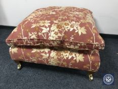 A contemporary oversized footstool in floral fabric