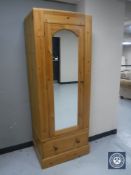 A pine mirror door wardrobe fitted a drawer (lacking cornice)