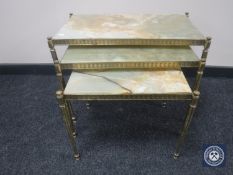 A nest of three brass and onyx tables
