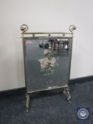 An Edwardian mirrored brass fire screen