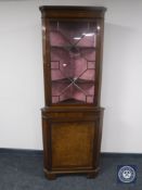 A mahogany glazed door corner cabinet