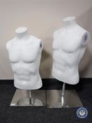 Two mannequin torsos on metal stands together with a box containing assorted mannequin parts