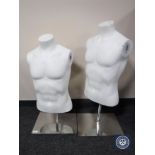 Two mannequin torsos on metal stands together with a box containing assorted mannequin parts