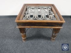 A contemporary hardwood and wrought iron coffee table