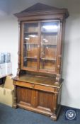 A 19th century oak glazed door bookcase fitted with cupboards and drawers