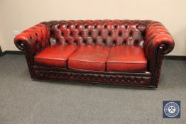 A pair of oxblood buttoned leather three seater settees, width 200 cm.