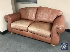 A three-piece tan leather lounge suite