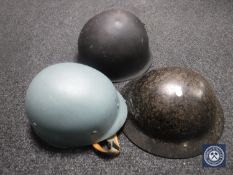 A post-war American helmet together with two other helmets