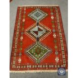 A Persian rug of geometric design on red ground 123 cm x 170 cm