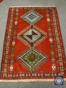 A Persian rug of geometric design on red ground 123 cm x 170 cm