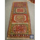 A Persian fringed rug of multi coloured geometric design,